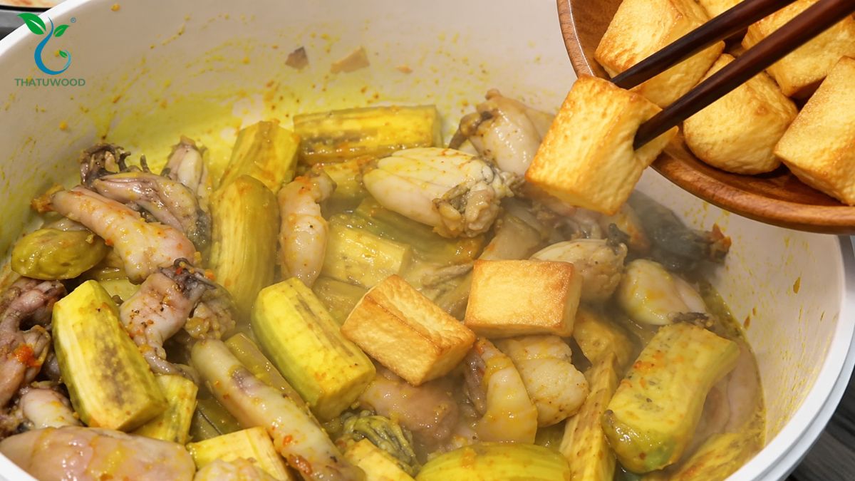 Ếch Om Chuối Đậu Đậm Đà, Thịt Mềm Ngọt Chuối Bùi Không Chát 4 Cho chuối xanh đậu phụ và thịt ếch vào nồi xào trước khi làm ếch om chuối đậu